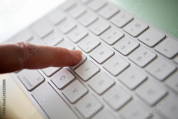 Obraz finger touching a key on a keyboard