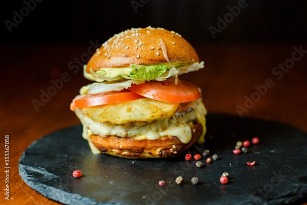 Obraz hamburger with chicken, pineapple and vegetables on a plate