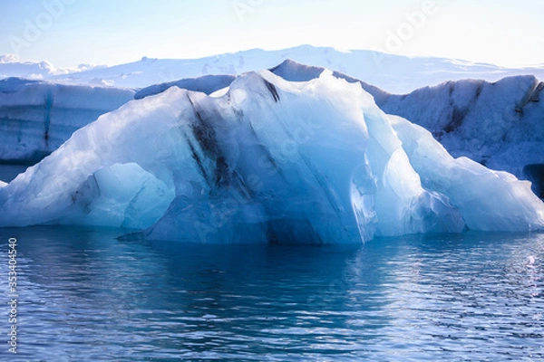 Fototapeta Icebergs floating. Ices and volcanic ash. Glacier lagoon. Melting ice. South coast Iceland.Volcanic ash on the arctic ice. Ice age glacier crevasse melting fast. Global warming. The edge of a glacier