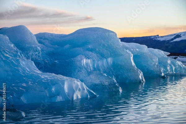 Fototapeta Icebergs floating. Ices and volcanic ash. Glacier lagoon. Melting ice. South coast Iceland.Volcanic ash on the arctic ice. Ice age glacier crevasse melting fast. Global warming. The edge of a glacier