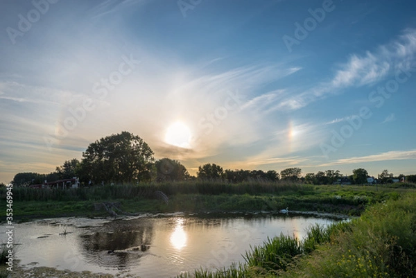 Fototapeta 22 degree circular halo with sundogs (parhelia) to the left and right of the sun. Meteorological optical phenomena.