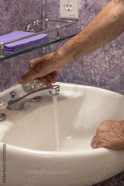 Fototapeta Bathroom sink man's hand turning on water