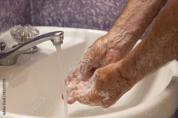 Fototapeta Close up soapy hands running water in sink