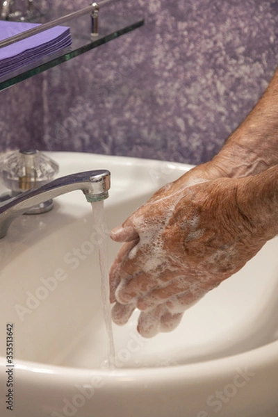 Fototapeta Soaping hands with running water bathroom sink vertical