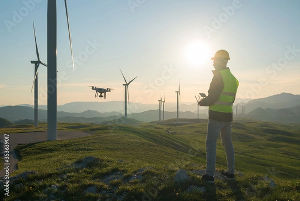 Fototapeta Technician Engineer in Wind Turbine Power Generator Station launches a drone for visual control of generators