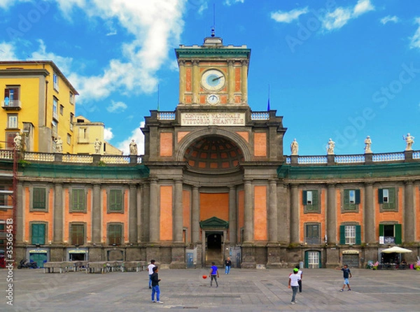 Fototapeta Children plays soccer in front Vittorio Emanuele II National Boarding School, historical and religious complex in Naples in Dante Square, Italy 