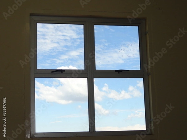 Fototapeta A classic window shape looking like a logo with clouds outside