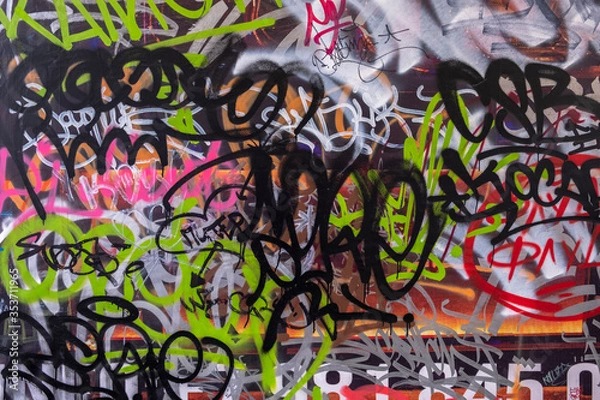 Fototapeta  wall painted with bright graffiti texts. rough surface texture