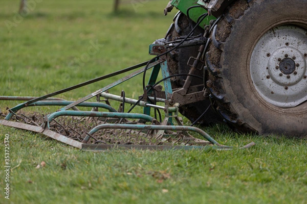 Fototapeta Traktor betreibt Weidepflege mit Weiseschleppe