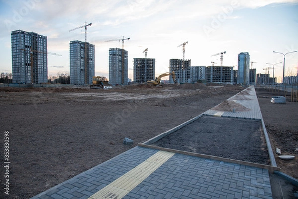 Fototapeta Laying paving slabs and borders at construction site. Process of installing paving bricks in the town pedestrian zone. Screeding the sand for install concrete blocks. Road works on pavement renovation