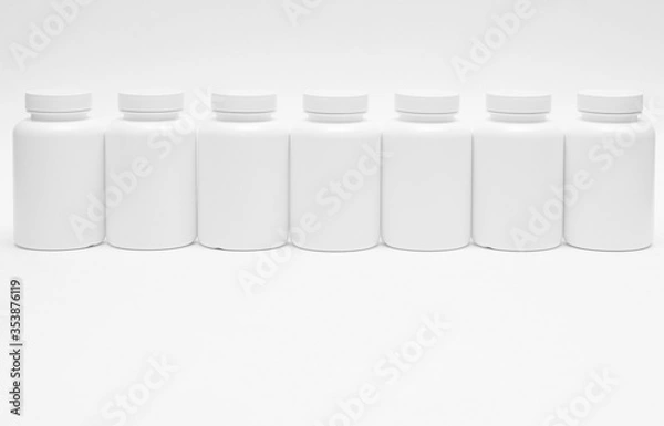 Fototapeta Seven white plastic containers for pills in a row isolated on white background