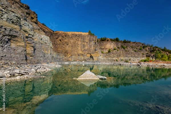 Fototapeta Abandoned granite and sand quarry with a lake. Stone extraction in the canyon.