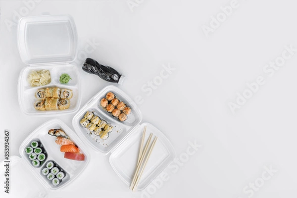 Obraz  Sushi and rolls set in a plastic box (top view). Delivery service consept.