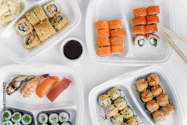 Obraz Set of rolls and sushi in a plastic box top view. Delivery service consept.