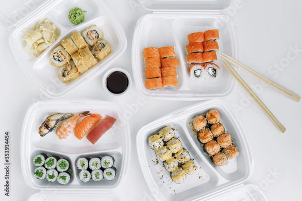 Obraz Set of rolls and sushi in a plastic box top view. Delivery service consept.