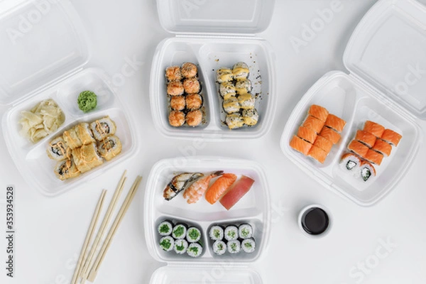 Obraz  Sushi and rolls set in a plastic box (top view). Delivery service consept.