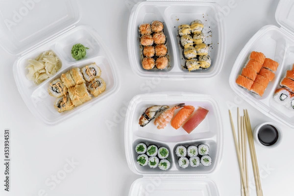 Obraz  Sushi and rolls set in a plastic box (top view). Delivery service consept.