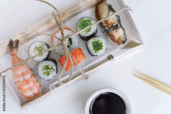 Obraz Sushi and rolls on take away recycling eco paper box. Delivery food concept.