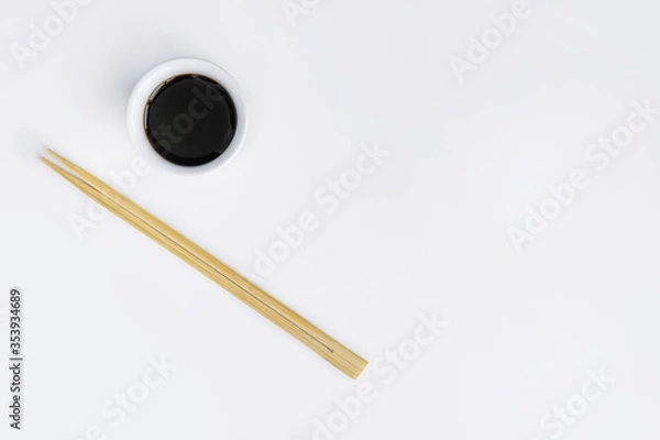 Obraz Chopsticks and soy sauce on white background (template, open space).