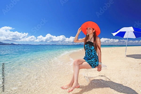 Obraz 波打ち際で寛ぐ笑顔の女性