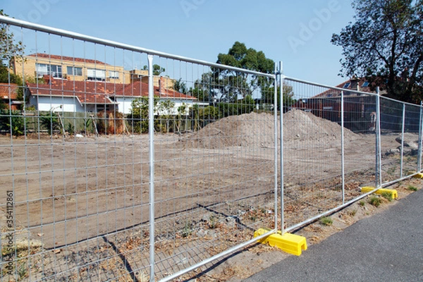 Obraz A new housing development under construction. A safety fence restricts access to the construction zone. 