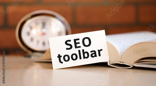 Fototapeta Seo toolbar concept text on a white background with a clock and an open book