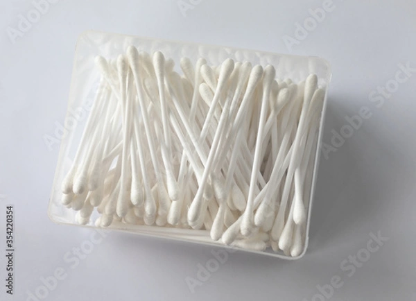 Obraz Container of mixed up cotton ear buds on a white background