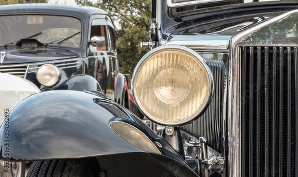 Fototapeta vintage caearly 1900s antique car ,view of the front of a historic car from the early 1900s, vision of the saddle, headlight and mudguard, reflectionsr headlight