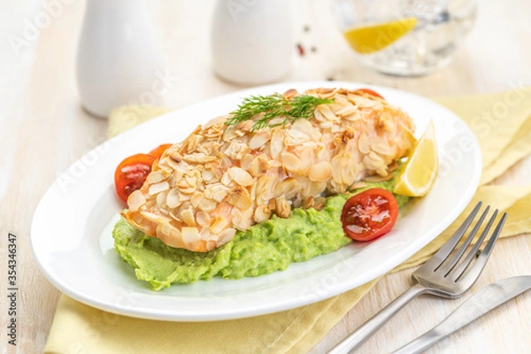 Fototapeta Salmon fillet fried in almond petals. Garnished with cauliflower and green peas puree.