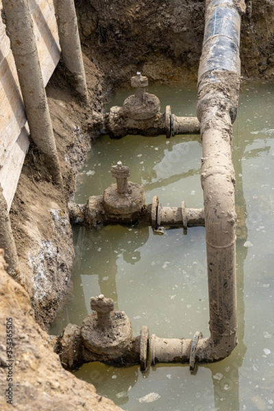 Fototapeta Used muddy water pipe valve in a trench
