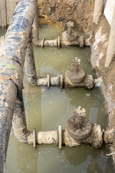 Fototapeta Used muddy water pipe valve in a trench