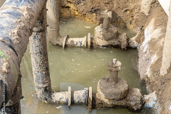 Fototapeta Used muddy water pipe valve in a trench