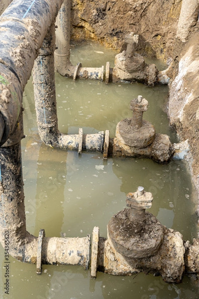 Fototapeta Used muddy water pipe valve in a trench