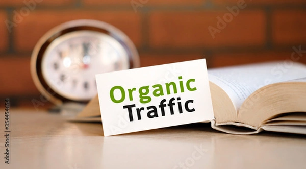 Fototapeta Organic seo traffic - concept text on a white background with a clock and an open book