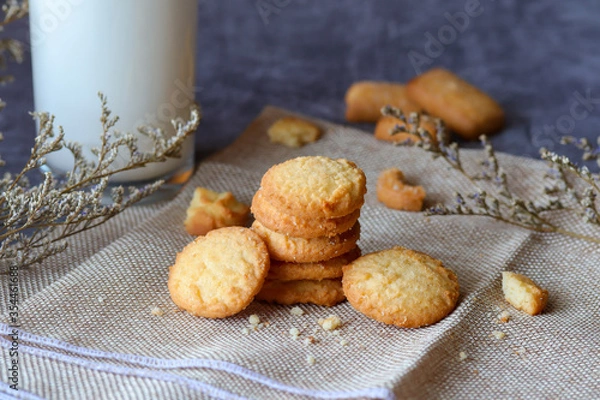 Obraz Fresh baked butter cookies with milk. Homemade oven cookies on a dark moody background.
