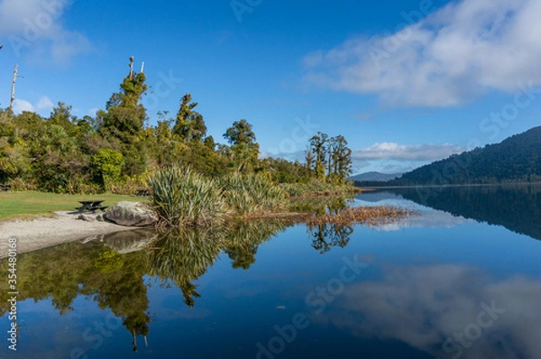 Fototapeta Lake landscape with mountain hills and reflection in still water
