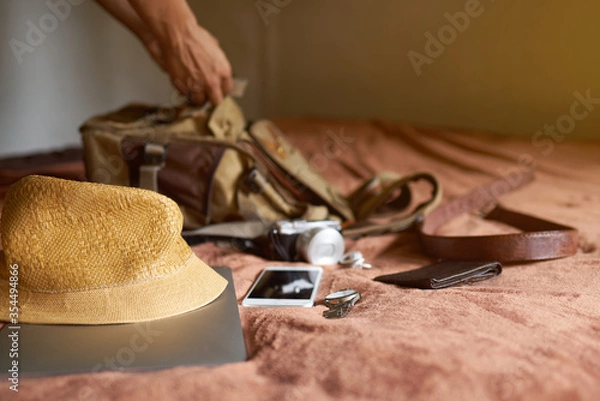 Obraz The idea of ​​traveling with a hat and bag and a laptop, then a man's hand picked from the bag.