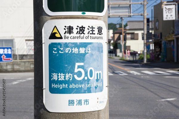 Fototapeta katsuura, chiba, japan, 09/01/2019 , Be careful of tsunami sign, attached in every pole of the city telling also how high on the sea level it is.