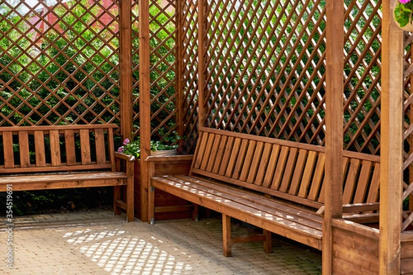 Obraz Interior of an openwork wooden gazebo. Cozy wooden gazebo in summer.