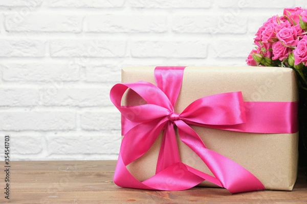 Fototapeta Bouquet of pink roses on a white brick wall background with copy space. The concept of flowers, floristry, holiday