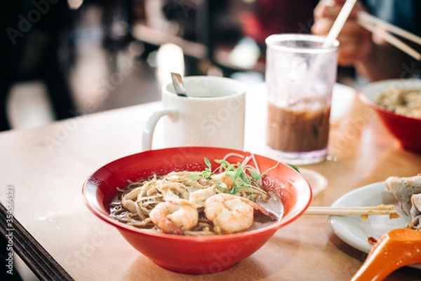Fototapeta prawn noodles on table with drinks in the background