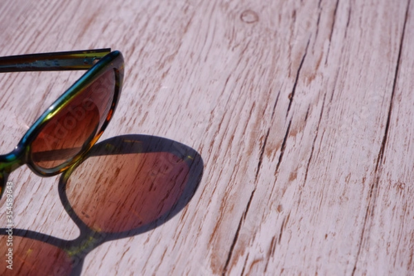 Obraz Sunglasses reflected  onto a wooden background