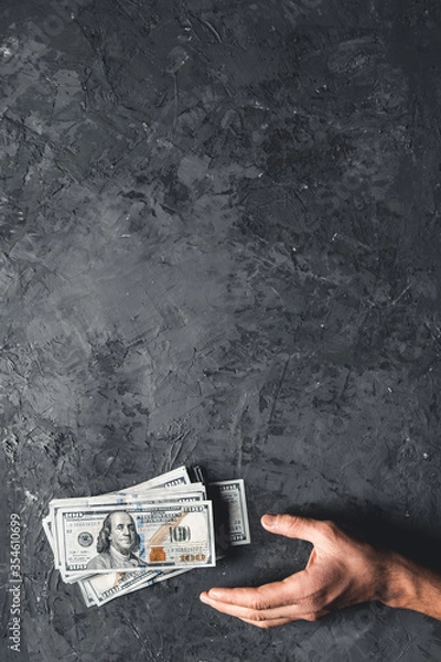 Fototapeta Hand holding money against dark background. Business concept, development perspective.
