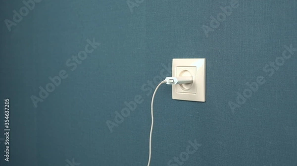 Fototapeta Charger mobile device is inserted into the socket