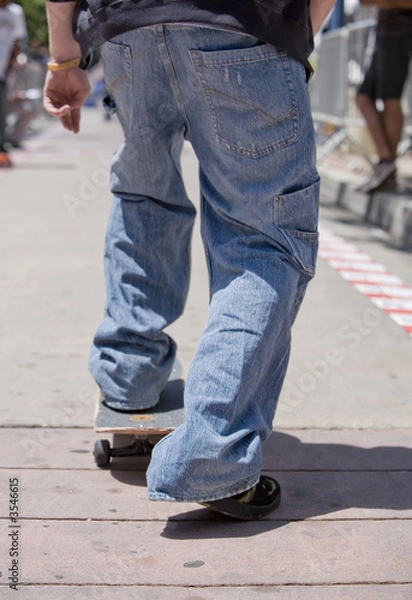 Obraz Vertical image of a skateboarder about to start skating