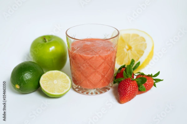 Fototapeta A glass of red cocktail with fruit on the white background. Apple, lime, lemon, strawberry. 