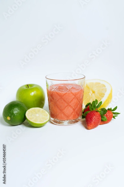 Fototapeta A glass of red cocktail with fresh fruit on the white background. Apple, lime, lemon, strawberry. 