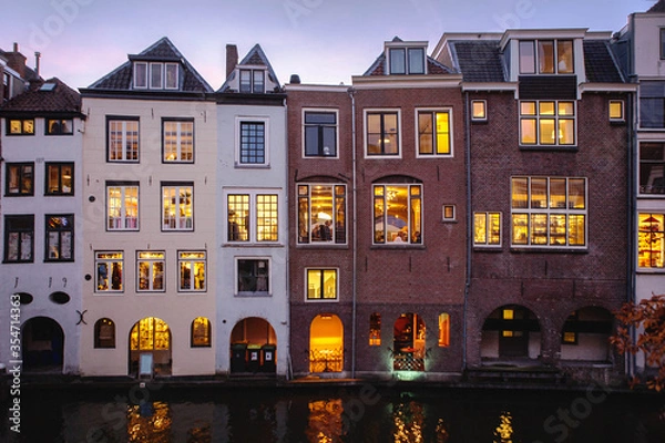 Obraz Foreshortening of the beautiful historical center of Utrecht City by night, with the characteristic houses illuminated view from a bridge crossing the dutch canals. Netherlands,Holland, Europe.