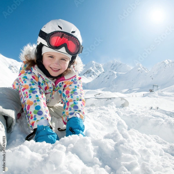 Fototapeta Narty, śnieg i zabawa - wesoły narciarz bawiący się na śniegu