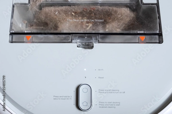 Fototapeta Cleaning the robot vacuum cleaner dust bin, robot vacuum cleaner maintenance service. Cleaning the trash bin of robot vacuum.